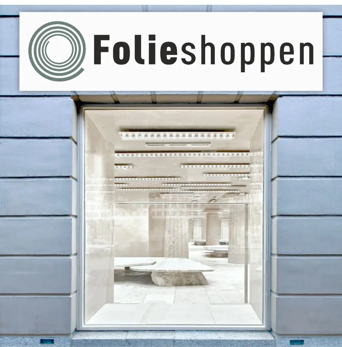 Rektangulært facadeskilt med logo og tekst over butiksvindue, høj kontrast for synlighed.