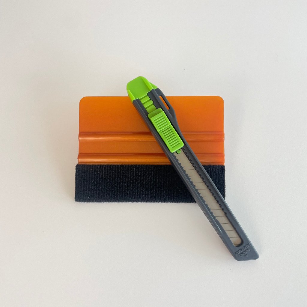 Orange skraber med glat kant og gråt kniv med grøn slider. Kompakt sæt til præcist arbejde.