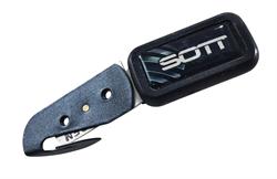 Værktøj med buet klinge og SOTT-logo på håndtaget. Kompakt og bærbar til håndholdt brug.