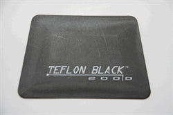 Sort teflonskraber med teksten "TEFLON BLACK 2000" trykt i hvidt. Flad og firkantet.
