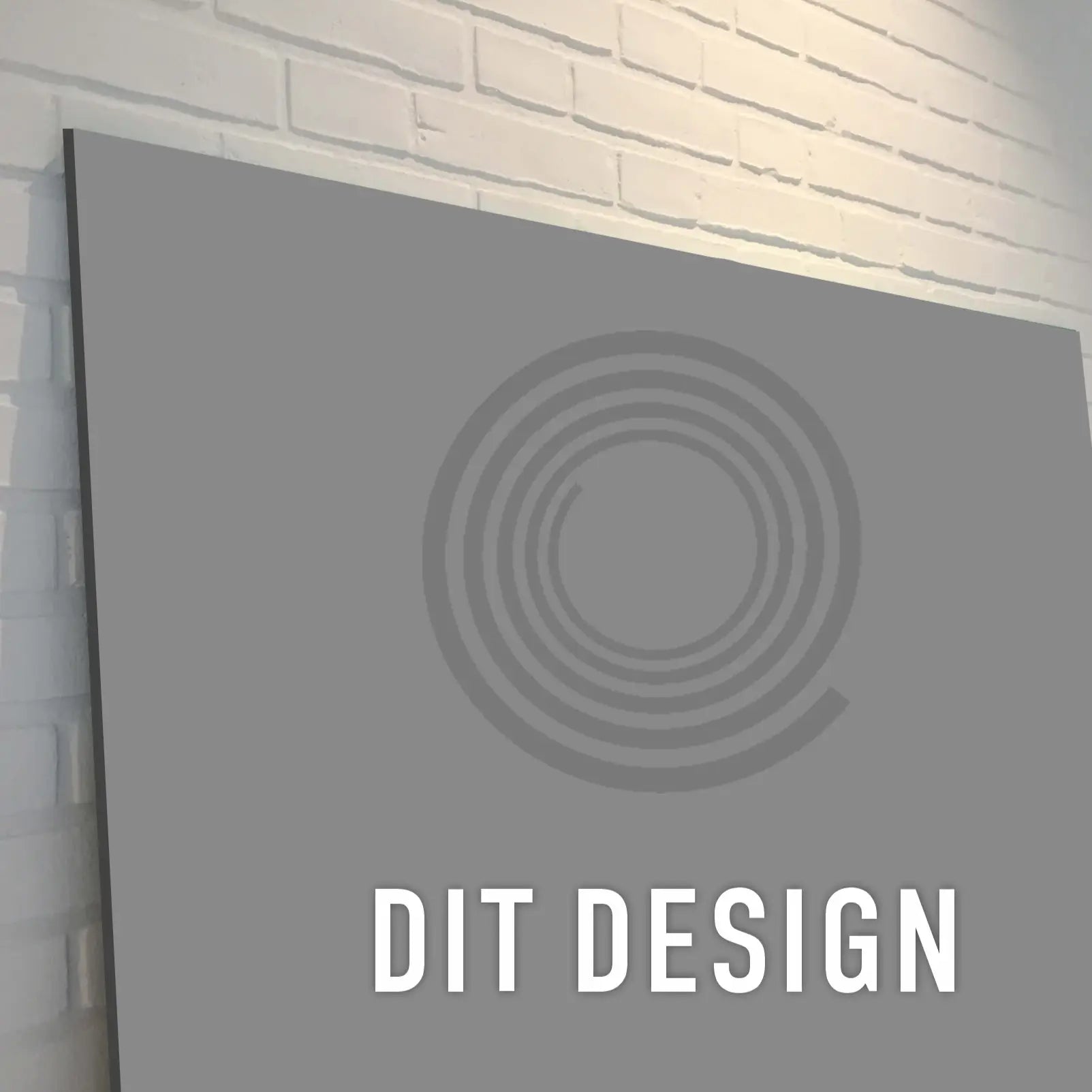 Firkantet skilt med cirkulære mønstre og teksten "DIT DESIGN" på en indendørs murstensvæg.