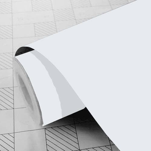 Rulle af hvidt mat folie med gridmønster på bagsiden. Folien er delvist rullet ud.