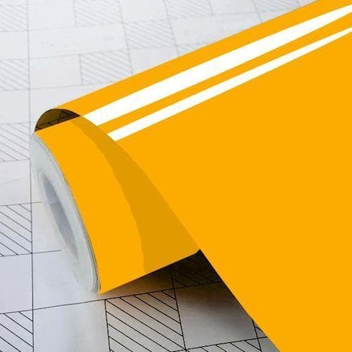 Skinnende gylden folie på rulle med glat, reflekterende overflade på gittermærket baggrund.