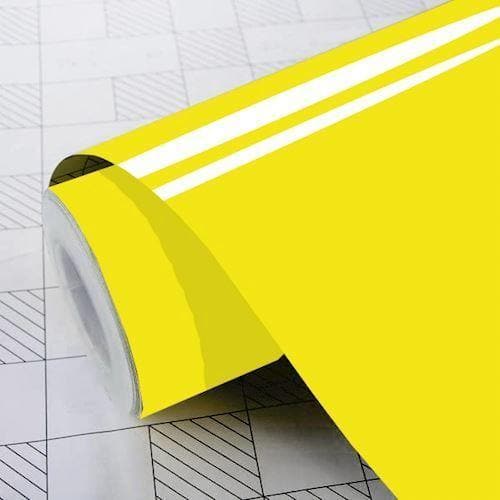 Blank gul folie med glansfuld overflade, rullet ud på et gittermønstret underlag.