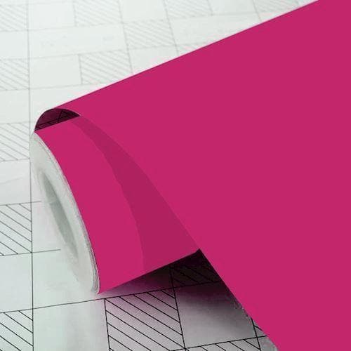 Pink folierulle med mat finish, let udrullet på ternet baggrund.