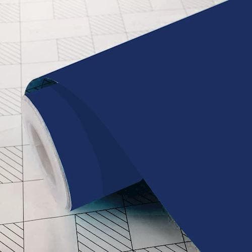 Mørkeblå mat folie rulle på en overflade med gittermønster, delvist udrullet.