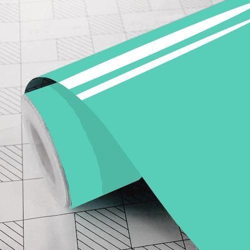 Rulle af mintfarvet, blank vinylfolie på et gittermønstret underlag.