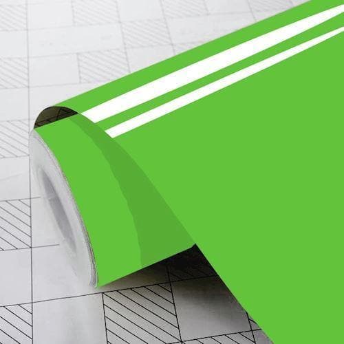 Rulle af skinnende limegrøn folie, delvist udrullet på overflade med gittermønster.