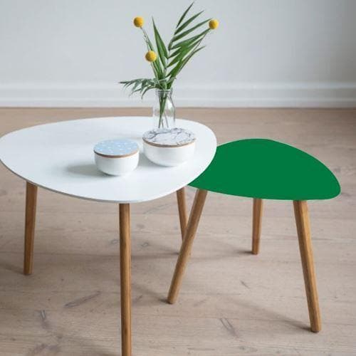 To små borde på trægulv; det ene hvidt med vaser og det andet med grøn overflade.