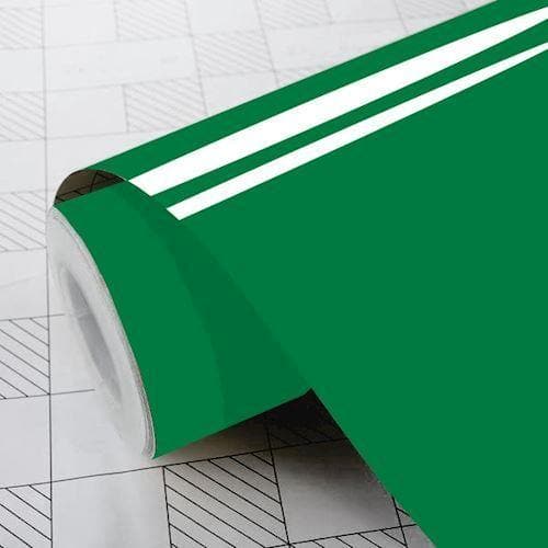 Rulle med blank, græsgrøn folie delvist udrullet på overflade med gittermønster.