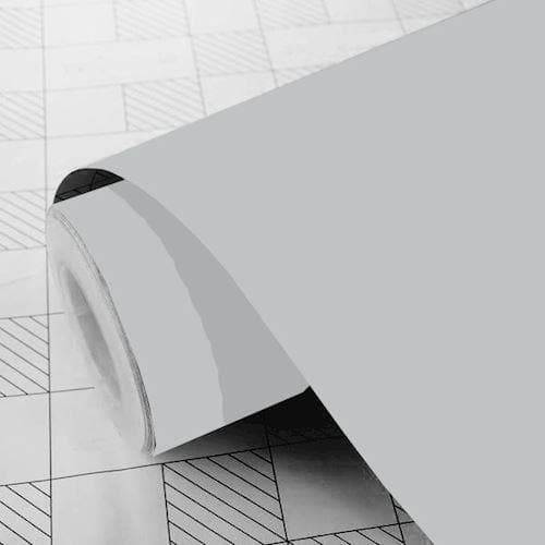 Rulle af lys grå mat folie på gittermønstret overflade.