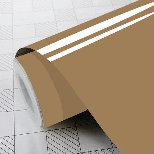 Rulle af lys brun, blank folie på et gittermønstret underlag, delvist udrullet med ensartet farve.