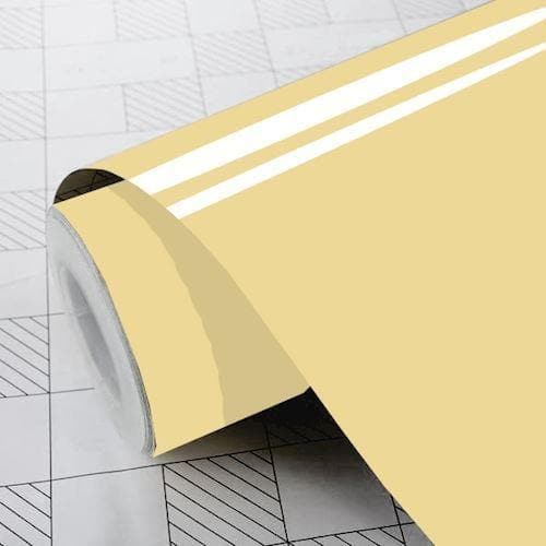 Cremefarvet folie med to hvide striber, delvist udrullet på gittermønstret overflade.