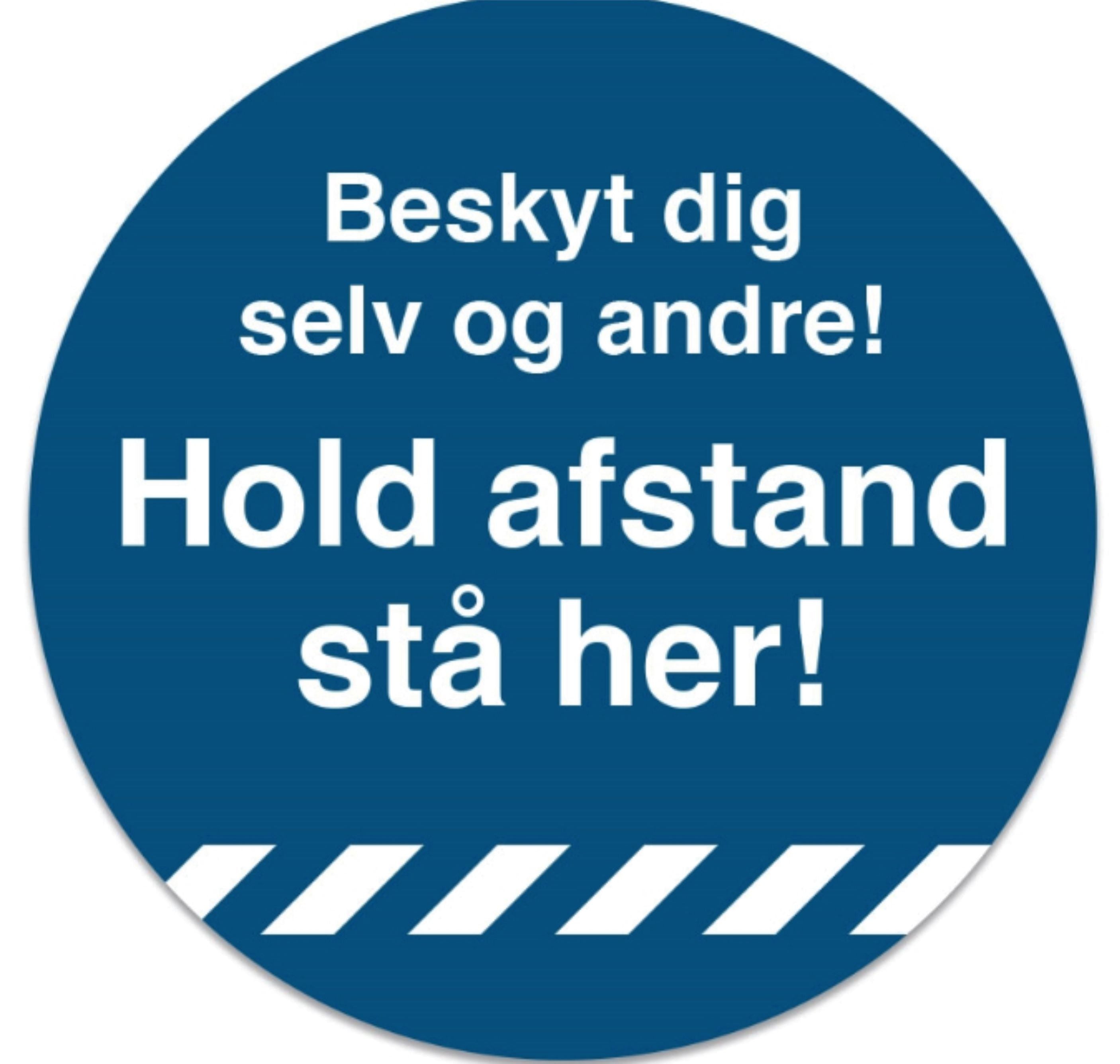 Blå cirkel med teksten: "Beskyt dig selv og andre! Hold afstand stå her!" Hvid tekst, skrå striber.