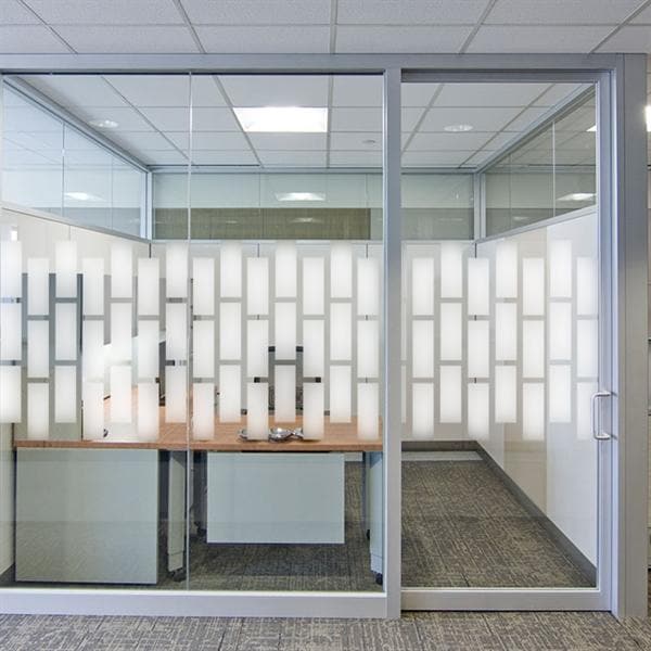 Glasvæg med sandblæst mønster, rektangulært design, der lader lys ind, men øger privatliv.