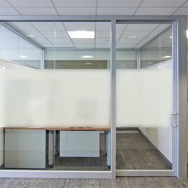 Kontor med frostet glasvæg, sandblæst design i midten giver delvis privatliv.