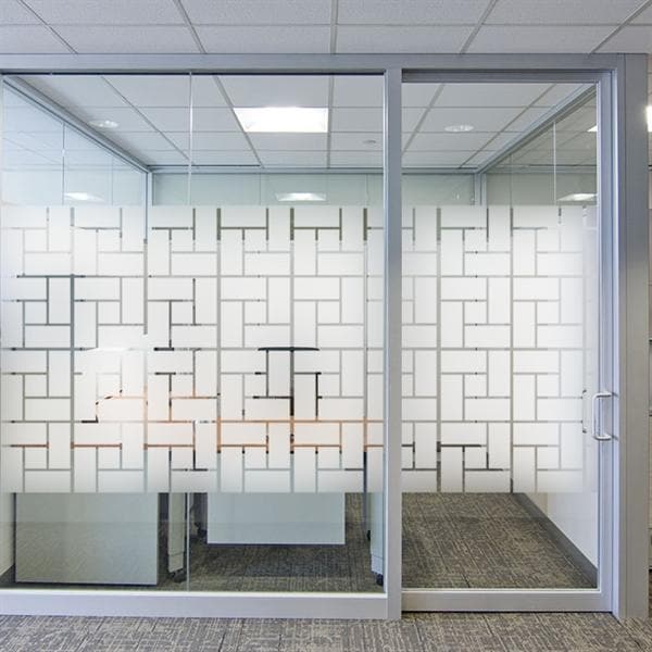 Glasplade med geometrisk mønster i frostet film, halvtranslucent for privatliv og lysindfald.