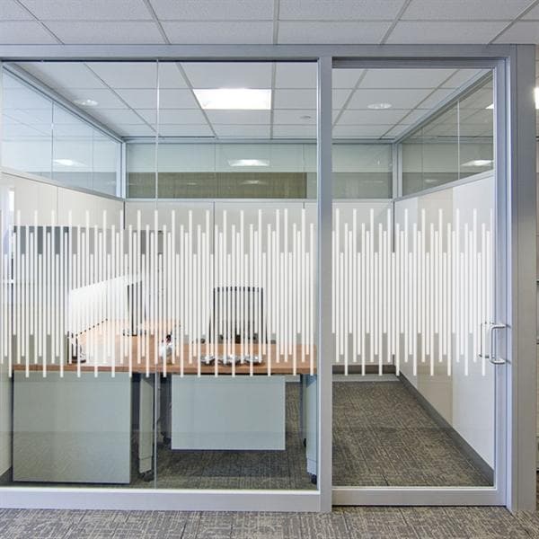 Glasvæg med sandblæst design af lodrette linjer, giver privatliv i kontorindretning. Minimalistisk stil.